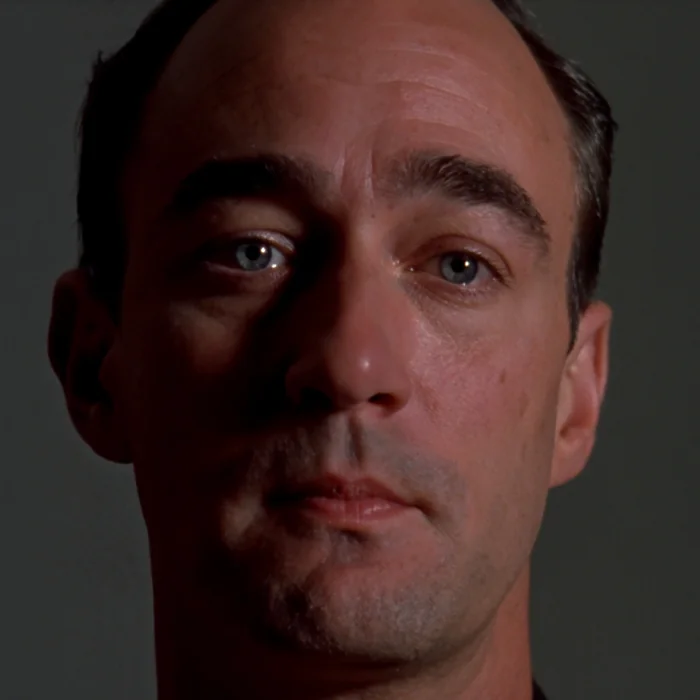 Primer plano neutro de un actor: ojos abiertos, sin expresión.